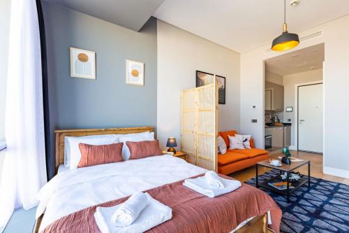a bedroom with a large bed and an orange couch at Studio Flat with Panoramic City View in Atasehir in Istanbul