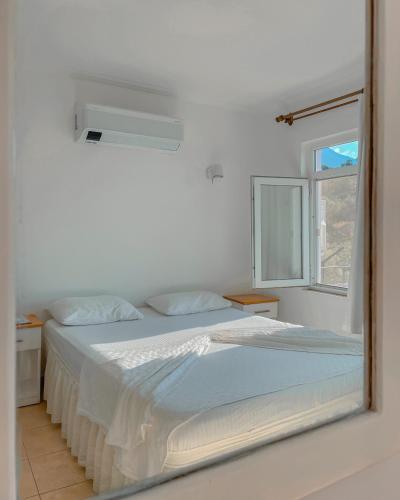 a white bedroom with a bed and a mirror at Hideaway in Kas