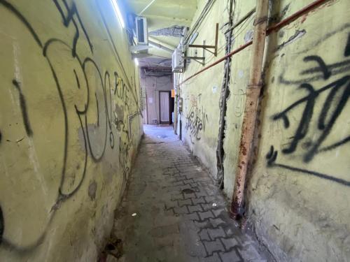 an alley with graffiti on the walls of an old building at CASA NEPTUN in OLD BATUMI in Batumi
