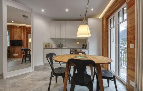 une cuisine et une salle à manger avec une table et des chaises en bois dans l'établissement Apartment Bonatti 201, à Chamonix-Mont-Blanc
