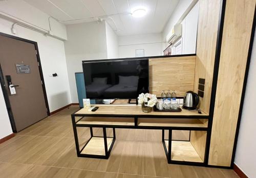 a table in a room with a large television at Golden Nest Hotel Suvarnabhumi in Bangkok