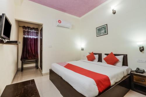 sypialnia z dużym łóżkiem i telewizorem w obiekcie Super OYO Flagship Ahinsha Cicle w mieście Dżajpur