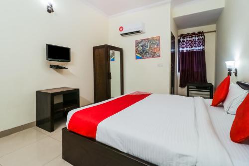 um quarto com uma cama grande e uma televisão em Super OYO Flagship Ahinsha Cicle em Jaipur