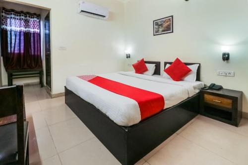 una camera da letto con un grande letto con cuscini rossi di Super OYO Flagship Ahinsha Cicle a Jaipur