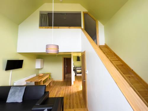 a living room with a staircase and a couch at Tarset Tor - Bothy Cabin 4 in Hexham