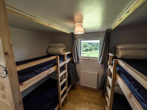 a room with two bunk beds and a window at Tarset Tor - Bothy Cabin 4 in Hexham