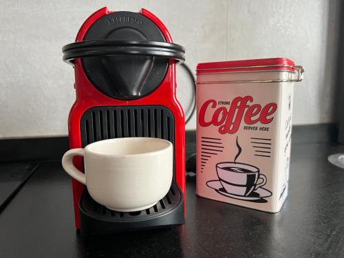 a coffee maker with a cup next to a can of coffee at Portubide Bermeo in Bermeo