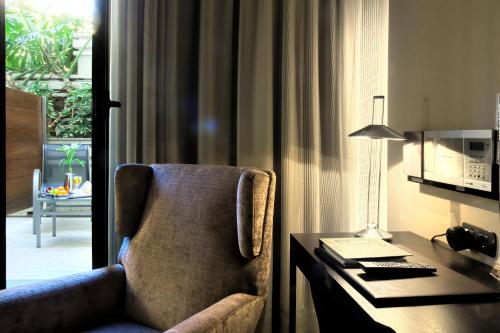 a room with a desk and a chair next to a desk with a desk at Gran Hotel Havana 4Sup by Escampa Hotels in Barcelona