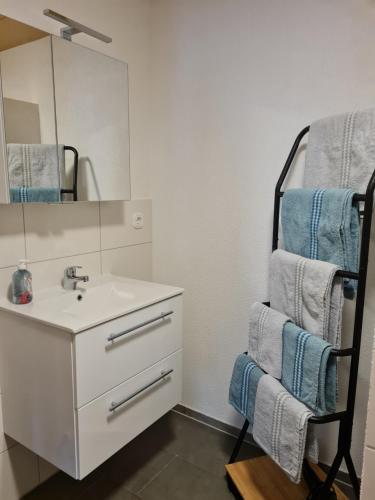 a bathroom with a sink and a mirror and towels at Ferienwohnung Chrissi in Bischofsheim an der Rhön