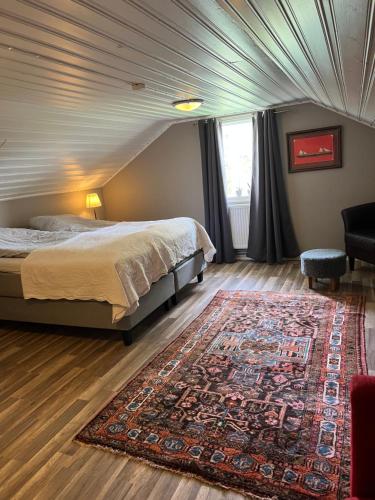 een slaapkamer met een bed en een groot tapijt bij Vänersborg in Vänersborg