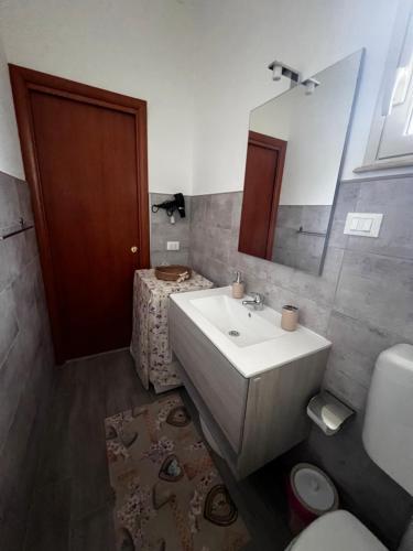 uma casa de banho com um lavatório, um WC e um espelho. em Casa I due Pini em Casa Modica