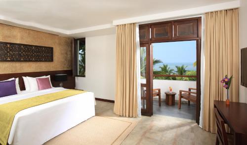 a bedroom with a bed and a view of the ocean at Avani Kalutara Resort in Kalutara