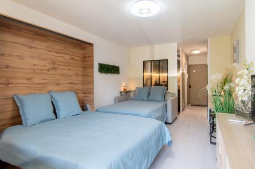 - 2 lits dans une chambre d'hôtel avec des oreillers bleus dans l'établissement Les Flamants Roses - Studio avec balcon, à Nîmes