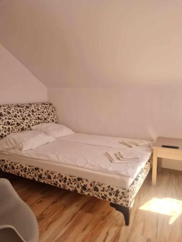 małe łóżko w pokoju ze stołem w obiekcie Pokoje Gościnne LENAILI w mieście Jarosławiec