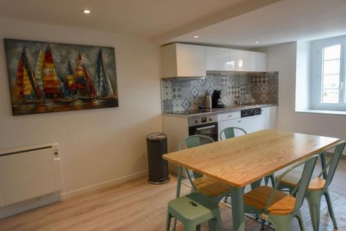 une cuisine avec une table en bois et quelques chaises dans l'établissement Les Remparts de Dinan . f3 intramuros. avec wifi, à Dinan