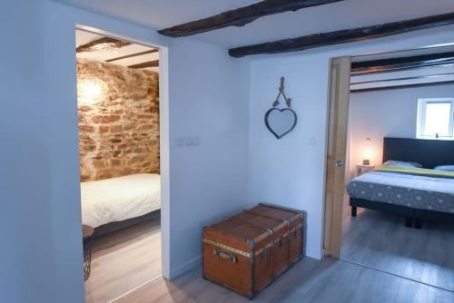Cette chambre comprend un lit et un coffre. dans l'établissement Les Remparts de Dinan . f3 intramuros. avec wifi, à Dinan