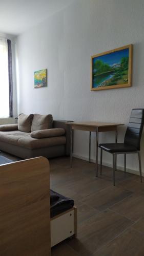 uma sala de estar com um sofá e uma mesa em Monteurzimmer em Frankfurt an der Oder