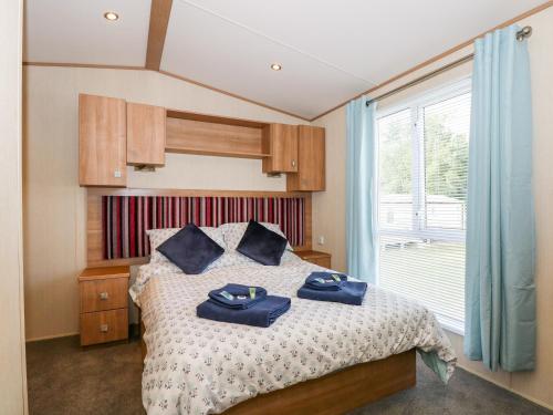 ein Schlafzimmer mit einem Bett mit blauen Handtüchern darauf in der Unterkunft 50, Foxburrow Hang in Great Yarmouth