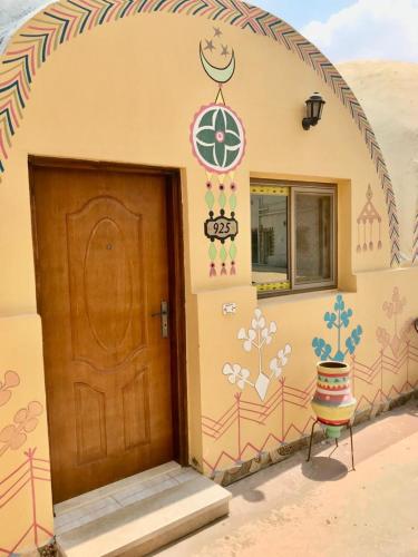 eine Eingangstür eines Hauses mit einer verzierten Wand in der Unterkunft Sahara Pyramids Hotel 
