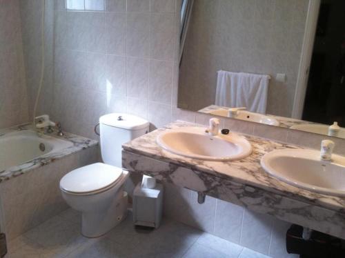 a bathroom with two sinks and a toilet and a tub at Villa Amina in Puerto del Carmen