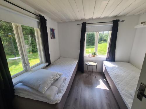 Lönsboda的住宿－Tosthult holiday 3，一间卧室设有两张床和两个窗户。