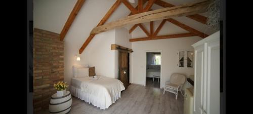 a bedroom with a white bed and a brick wall at Vinný Tunel - Vinný rodinný pokoj in Pouzdřany