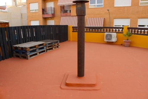 a pole in the middle of a patio with a bench at Vacaciones tierra y mar Casa en el centro con patio y terraza in El Campello