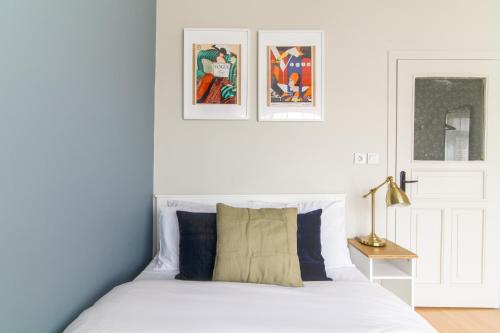 a bedroom with a white bed with two pictures on the wall at Chic and Cozy Flat Near Istiklal Street in Beyoglu in Istanbul