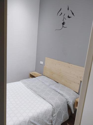 ein kleines Schlafzimmer mit einem Bett mit weißer Bettwäsche in der Unterkunft Céntrico apartamento con patio in Madrid