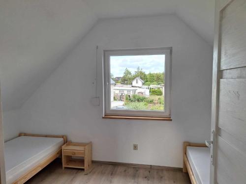 a room with two beds and a window at Domek letniskowy w Trzęsaczu in Trzęsacz