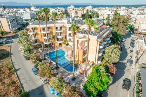 een uitzicht op een gebouw met een zwembad en palmbomen bij Kos City Apartments in Kos-stad