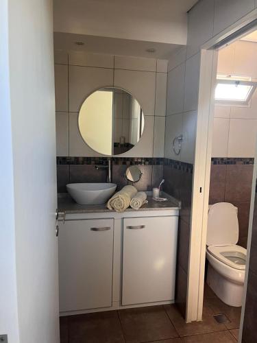 een badkamer met een wastafel, een toilet en een spiegel bij Departamento Los Jilgueros in Posadas