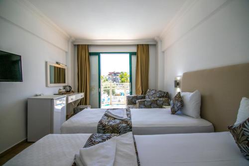 een hotelkamer met 2 bedden en een bank bij Bahar Hotels in Fethiye