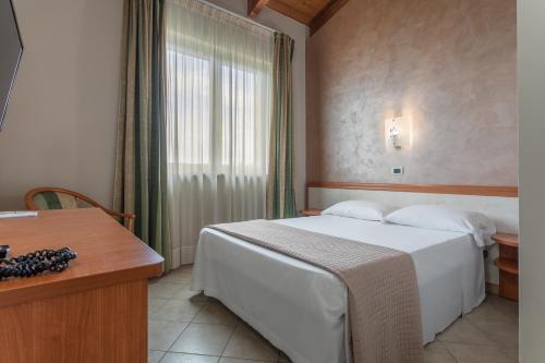 una camera con un letto bianco e una finestra di Hotel Prestige a Montesilvano