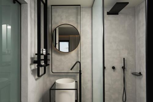 a bathroom with a shower and a mirror at Apikia Santorini in Pirgos