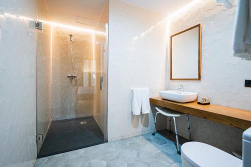 y baño con ducha, lavabo y espejo. en Málaga Premium Hotel en Málaga