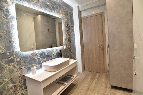 a bathroom with a white sink and a mirror at Comfort Spot 1 in Kavala