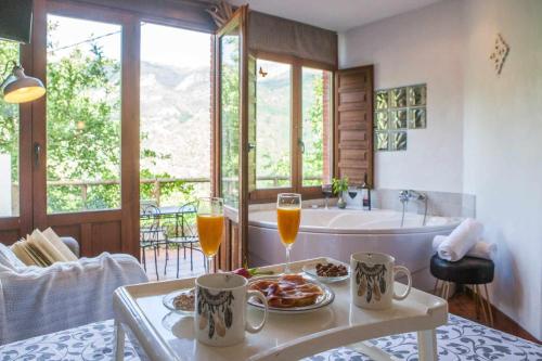 ein Badezimmer mit einer Badewanne und einem Tisch mit Speisen und Getränken in der Unterkunft El Ablanu Senda del Oso in Proaza