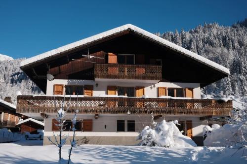 a building with snow on the ground in front of it at Chalet la Dransette in Châtel