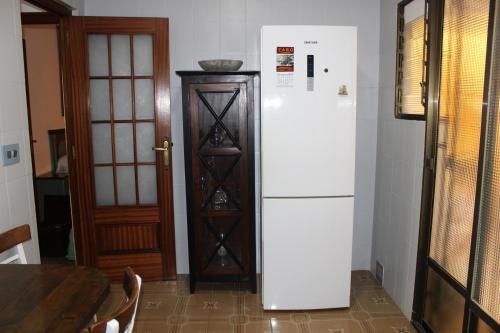 a white refrigerator in a kitchen next to a table at Vacaciones tierra y mar Casa en el centro con patio y terraza in El Campello