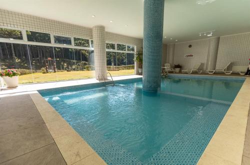 a large swimming pool in a building at Satélite - Campos do Jordão in Campos do Jordão