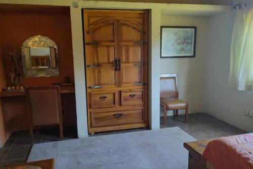 a bedroom with a wooden cabinet and a mirror at Casa Boutique La Loma in Huasca de Ocampo
