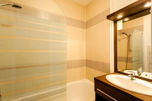 y baño con lavabo, bañera y espejo. en La Cabre d'Or - Duplex avec piscine partagée en Cabriès