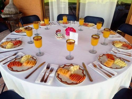 a table with plates of food and glasses of orange juice at Casa Boutique La Loma in Huasca de Ocampo