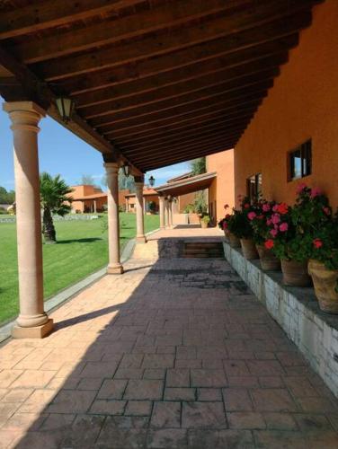 a brick walkway leading to a building with potted plants at Casa Boutique La Loma in Huasca de Ocampo