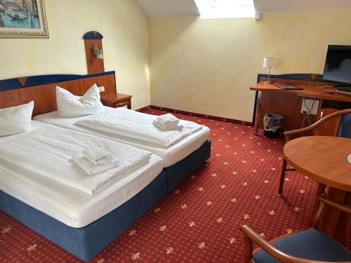 a hotel room with a large bed and a desk at Hotel Ostseeblick - direkt hinter den Dünen in Ostseebad Karlshagen