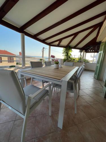 einen Holztisch und Stühle auf einer Terrasse in der Unterkunft Villa Stina in Pisak