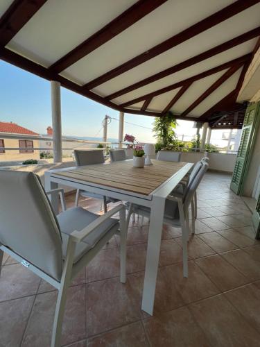 a wooden table and chairs on a patio at Villa Stina in Pisak