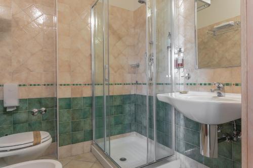 a bathroom with a shower and a sink and a toilet at Hotel Prestige in Montesilvano