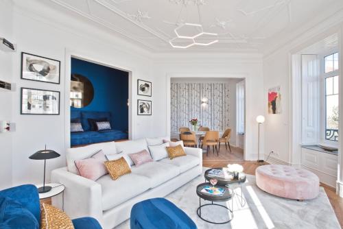a living room with a white couch and a blue wall at JOIVY Luxury 3 bed, 3 bath flat with terrace, near Estrela Garden in Lisbon